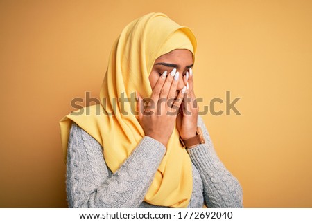 Young beautiful african american girl wearing muslim hijab over isolated yellow background rubbing eyes for fatigue and headache, sleepy and tired expression. Vision problem