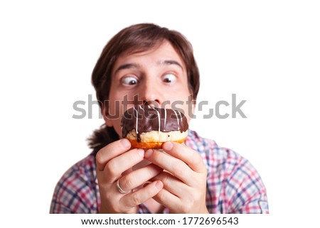 Funny man looks at the chocolate doughnut bulging eyes
