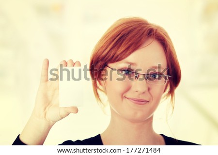 Redhead female person with blank business card in hand.  