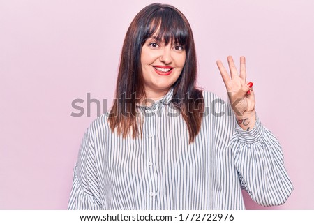 Young plus size woman wearing casual clothes showing and pointing up with fingers number three while smiling confident and happy. 