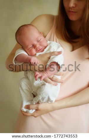 young woman holding newborn baby at home 