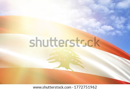 flag of Lebanon against the blue sky with sun rays