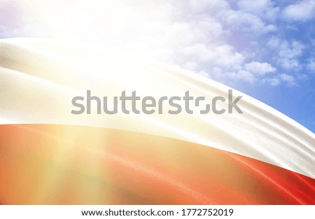 flag of Poland against the blue sky with sun rays