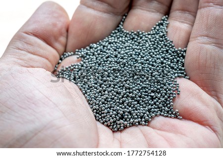 View of the circular steel grits in the palm for abrasive or sandblasting. Steel grits are produced by fracturing high carbon steel balls after heat treatment. Steel grits have high resistance. Royalty-Free Stock Photo #1772754128