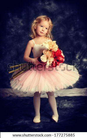 Pretty little girl ballerina in tutu posing over vintage background.