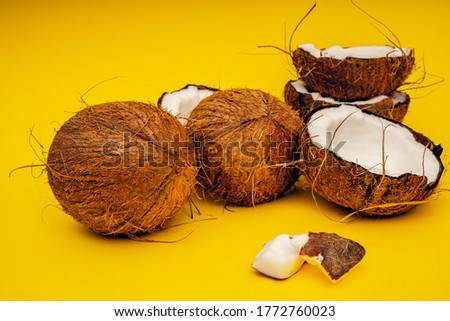 Parts of coconut on a colored background. Close up. Fresh ripe coconut broken into pieces
