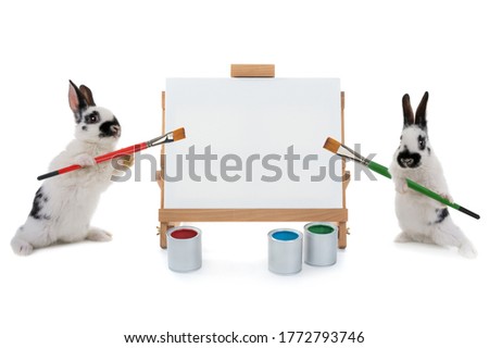 Two bunnies stand at the easel with tassels isolated on a white background. for writing your text
