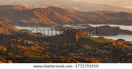 Beautiful autumn landscape of a church on a hill in Slovakia. Idyllic scenery from a bird's eye view of the picturesque town of Banska Stiavnica Royalty-Free Stock Photo #1772793950