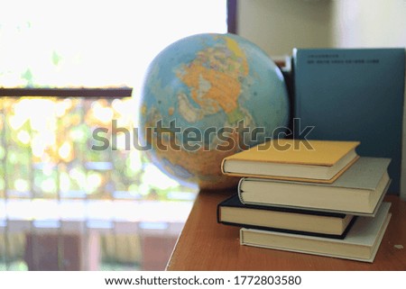 Close-up of books stacked on bookshelf in library Globe as background selective focus and shallow depth of field