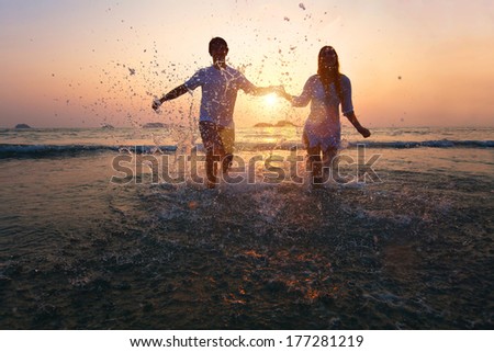 happy couple enjoy sunset on the beach