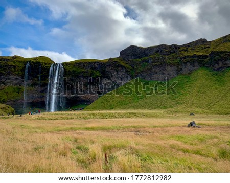 Scenic view of Seljalandsfoss waterfall at sunny day in Iceland famous waterfall landscape with green hills and rocks