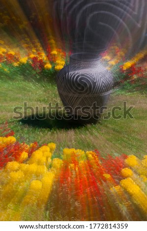 Abstract photography with long exposure and zoom-in teqnicue. Ornamental black ceramic vase in the garden.