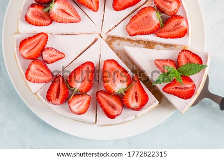 Sweet breakfast, delicious cheesecake with fresh strawberries and mint, homemade recipe without baking, on blue stone table. Copy space. Royalty-Free Stock Photo #1772822315