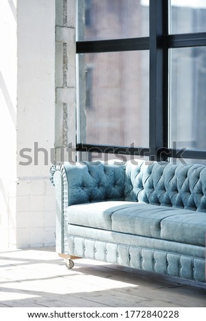 Loft interior. Blue sofa in sunshine room .Selective focus