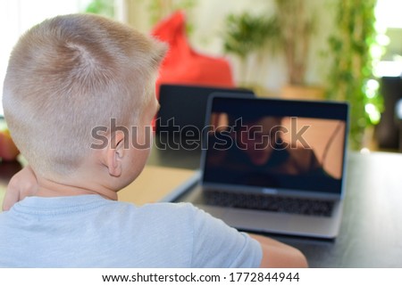 boy watching a movie at home on a laptop. children's leisure at home