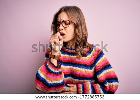 Young beautiful blonde girl wearing glasses and casual sweater over pink isolated background feeling unwell and coughing as symptom for cold or bronchitis. Health care concept.