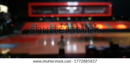Blurred indoor stadium with bokeh light effect.