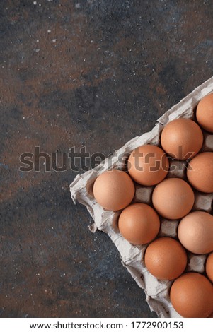 overhead view of brown chicken eggs in an open egg carton isolated on grain background. Fresh chicken eggs background. Top view with copy space. Natural healthy food and organic farming concept.