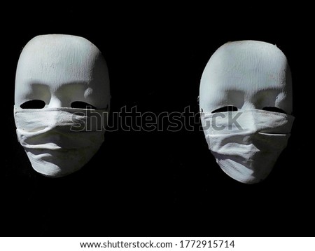 The picture of twin Carnival masks worn with germ-proof masks with beautiful lighting.Is a symbol for people to follow during the outbreak of corona virus (Covid-19),With a black background.