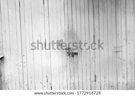 Old wooden door and concrete wall, black and white detail, grunge and rough urban spaces, geometric aspects, texture contrasts, with decadence concept.
