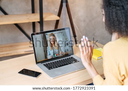 Video call to female employee or friends. Two woman is talking online via video connection on laptop indoor, they are greeting each other. Virtual meeting Royalty-Free Stock Photo #1772923391