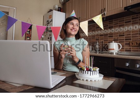Girl celebrating birthday online in quarantine time. make a wish and blow out the candles on the cake.