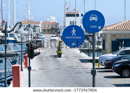 Road in sea harbor with two blue mandatory traffic signs  for cars and pedestrians 