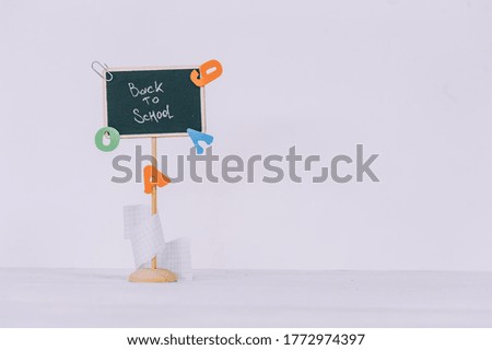 Concept Back to School. The plate with the inscription and colored letters on a light background