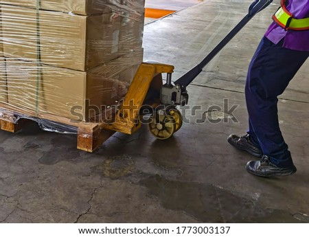 Worker loading and unloading shipment carton boxes and goods on wooden pallet by forklift  from container truck to warehouse cargo storage in logistics and transportation industrial 