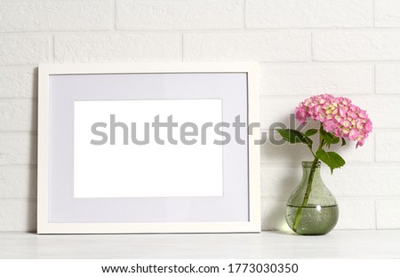 Empty white frame with pink hydrangea flowers