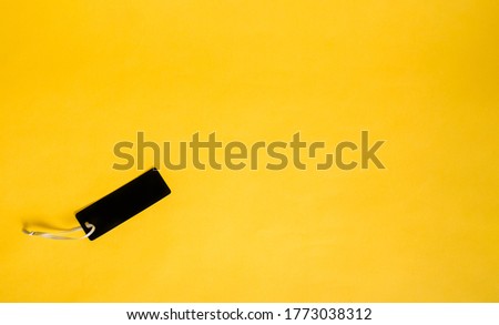 black tag on a yellow isolated background with space for text