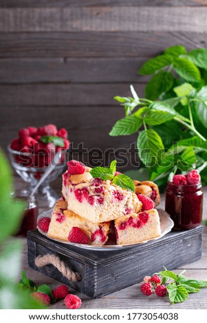 Pieces of homemade raspberry cake on a plate with fresh raspberry berries and mint. Selective focus