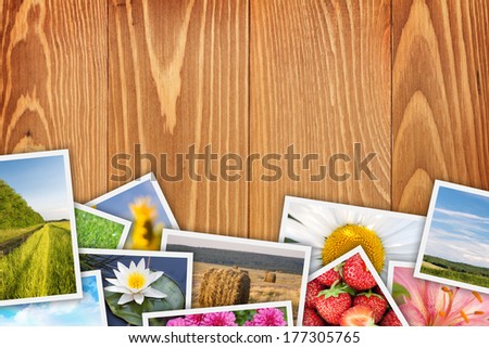 Stack of printed pictures collage on wooden table with copy space for your text or photo
