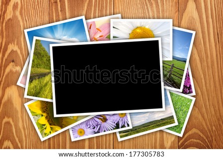 Stack of printed pictures collage on wooden table with copy space for your photo