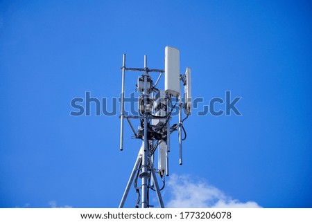 Macro Base Station or Base Transceiver Station. Telecommunication tower with antennas of 4G and 5G cellular against blue sky background. Development of communication system in urban area. 