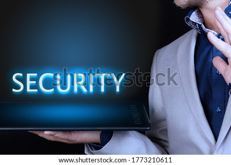 Businessman, man holds in his hand a tablet with a neon word, SECURITY text. Business concept.
