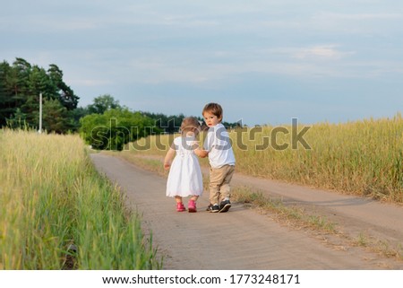 The boy is carefully holding the girl's hand they are looking into the distance. High quality photo