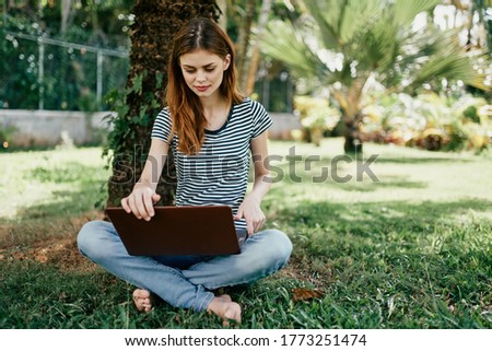 Woman with notebook near a tree on the nature in the park