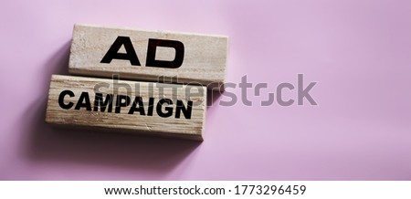 Ad Campaign on Wooden Blocks on pink background. Marketing advertising Business Concept