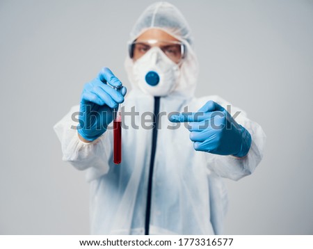 Doctor with fluid in the flask and in medical gloves mask on the face covid-19