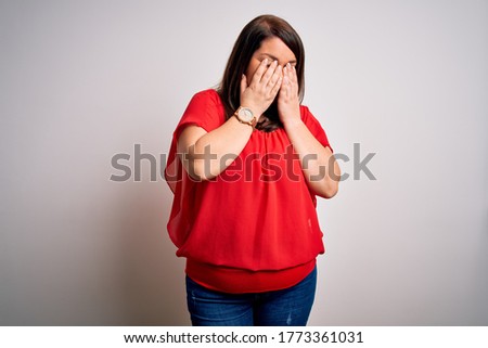 Beautiful brunette plus size woman wearing casual red t-shirt over isolated white background rubbing eyes for fatigue and headache, sleepy and tired expression. Vision problem