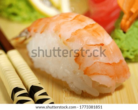 Sushi with shrimp on a wooden tray close-up.
