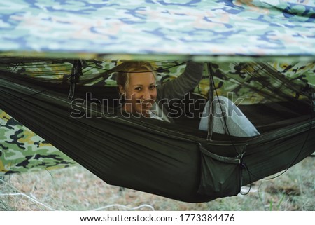 Beautiful young woman in a hammock on a camping trip. Camping life concept.