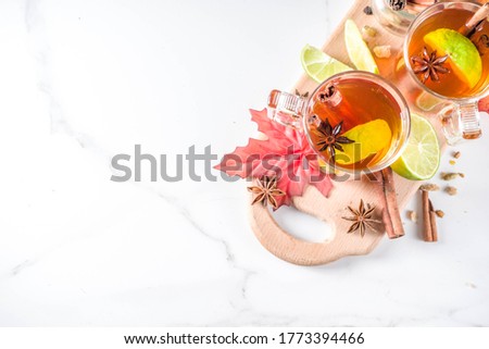 Hot spicy autumn tea with cinnamon, anise, lemon, with autumn decoration, leaves and spices