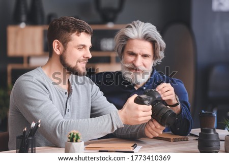 Mentor teaching young photographer in studio