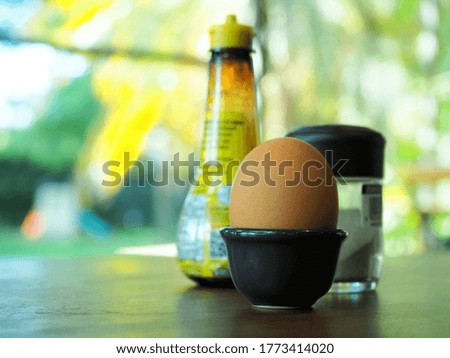 The picture of a healthy breakfast with perfect boiled eggs, served with pepper and soy sauce.