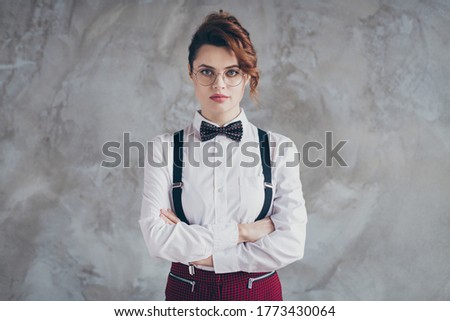 Portrait of her she nice-looking well-dressed attractive lovely chic serious wavy-haired girl folded arms isolated over gray concrete industrial wall background