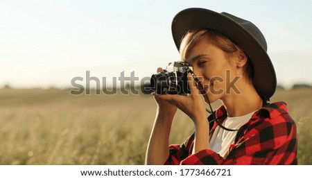 Close up portrait of beautiful hipster girl taking photo on retro camera