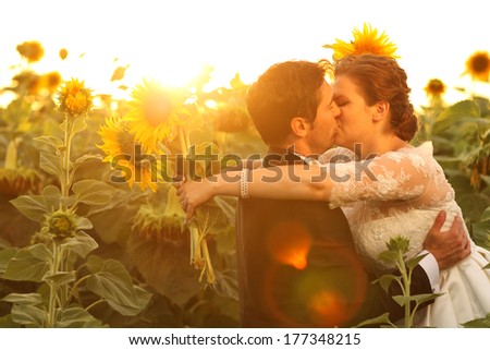 Beautiful couple having fun in sunflowers fields