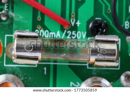 Blown defective fuseinstalled  on electronic green circuit board macro  Royalty-Free Stock Photo #1773505859